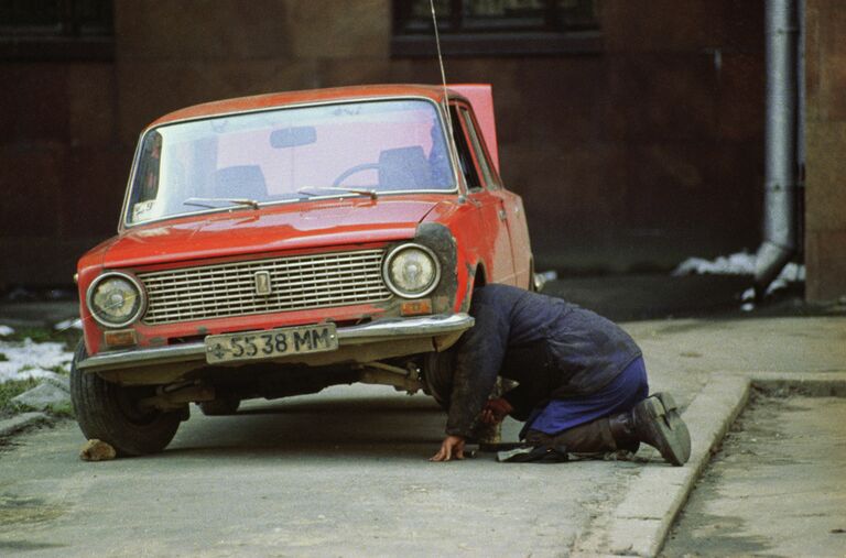 Мужчина ремонтирует старый автомобиль