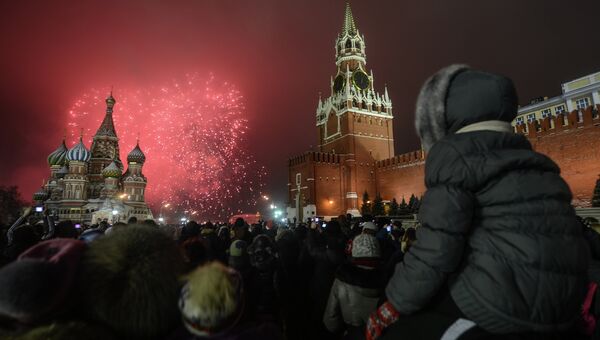 Москвичи и гости столицы, встречающие Новый Год на Красной Площади, наблюдают праздничный салют
