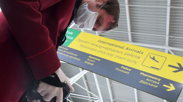 Сотрудник санитарно-карантинного пункта проводит дистанционную термометрию пассажиров, прибывших в международный аэропорт в Казани