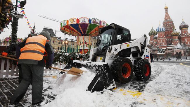 Сотрудники коммунальной службы убирают снег на Красной площади в Москве