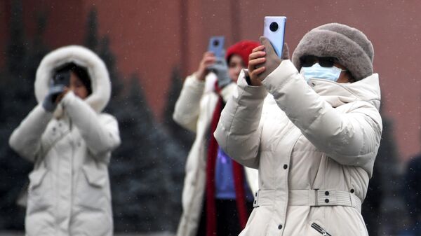  Иностранные туристы в защитных масках на Красной площади в Москве