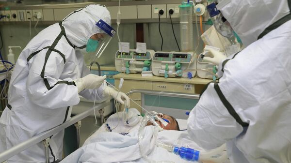 Медицинский персонал в защитных костюмах в больнице университета Ухань
