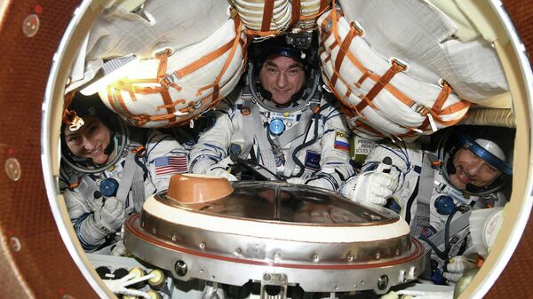Космонавт Александр Скворцов и астронавты Лука Пармитано и Кристина Кук во время тренировки по спуску на корабле Союз МС-13