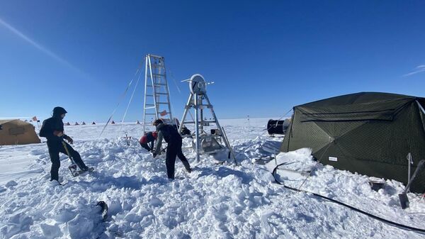 Ученые из Нью-Йоркского университета и Центра глобального изменения уровня моря в Абу-Даби откапывают буровую площадку после снегопада