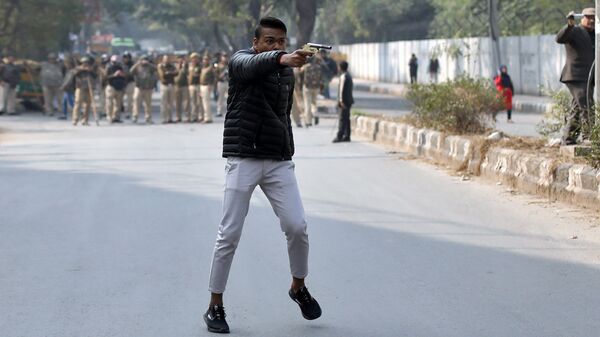 Вооруженный мужчина на акции протеста в районе Национального исламского университета в Нью-Дели. 30 января 2020