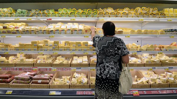 Женщина у прилавка с сырами в магазине