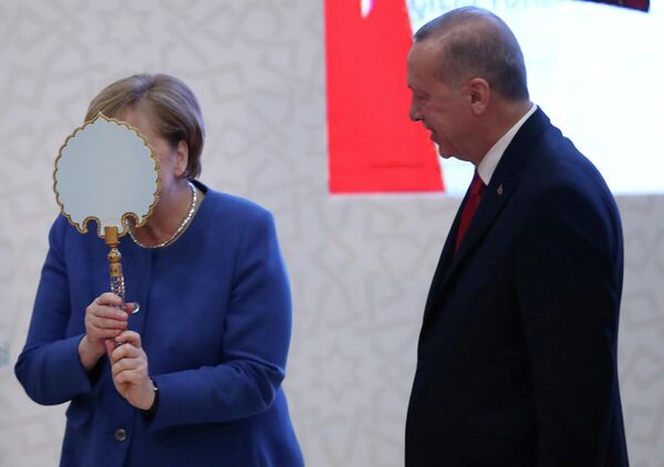 Канцлер Германии Ангела Меркель получает подарок от президента Турции