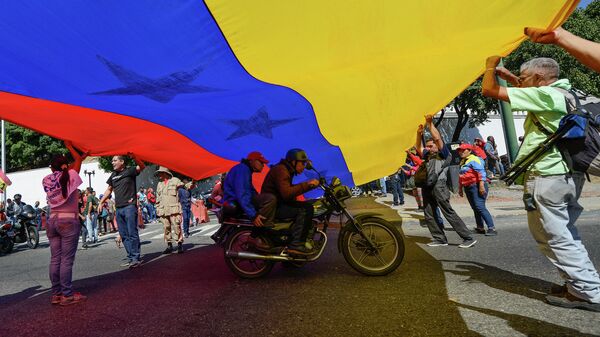 Люди с флагом Венесуэлы в Каракасе