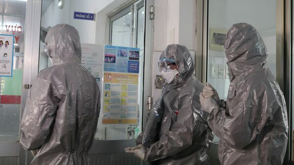 Врачи в защитных костюмах в больнице города Хошимин