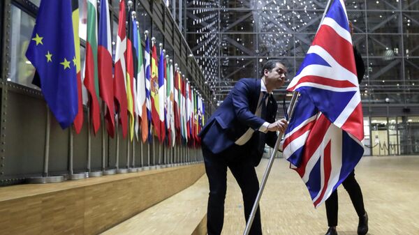 Сотрудники протокола убирают флаг Великобритании у здания Европы в Брюсселе