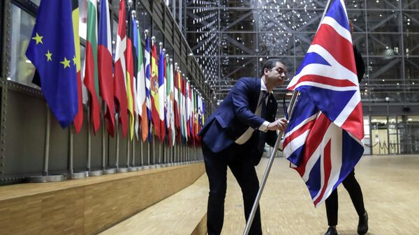 Сотрудники протокола убирают флаг Великобритании у здания Европы в Брюсселе
