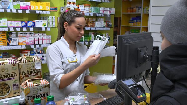 Сотрудник аптеки продает медицинские маски