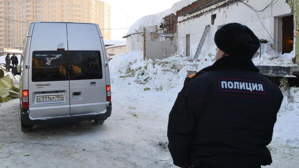 Автомобиль следственного комитета РФ и сотрудник полиции на месте обрушения кровли кафе в Новосибирске