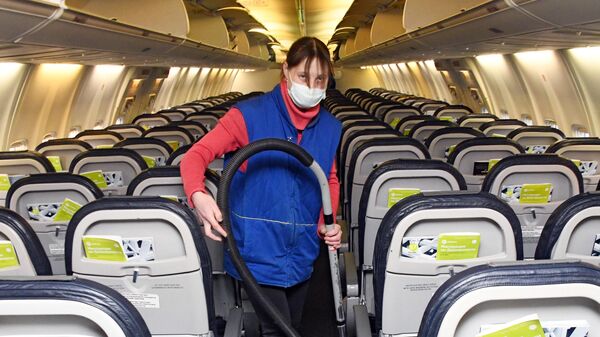Сотрудница клининговой компании проводит уборку салона самолета в аэропорту Читы