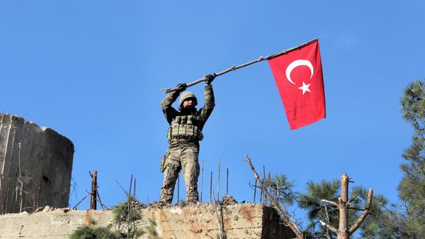 Турецкий военный с флагом на территории Сирии