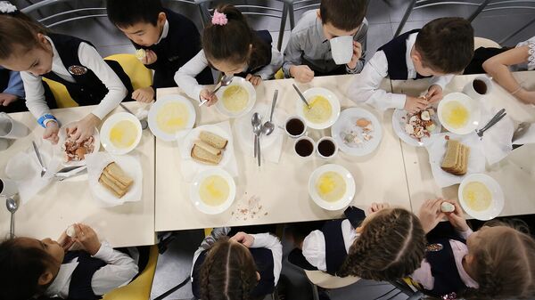 Ученики школы обедают в столовой