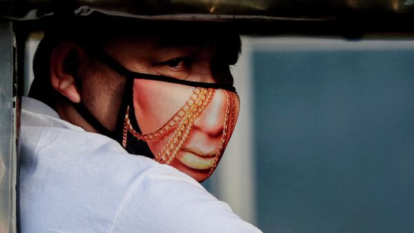 Мужчина в защитной маске с рисунком в Кесон-Сити, Филиппины