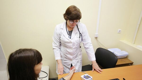 Врач-педиатр измеряет артериальное давление пациентке