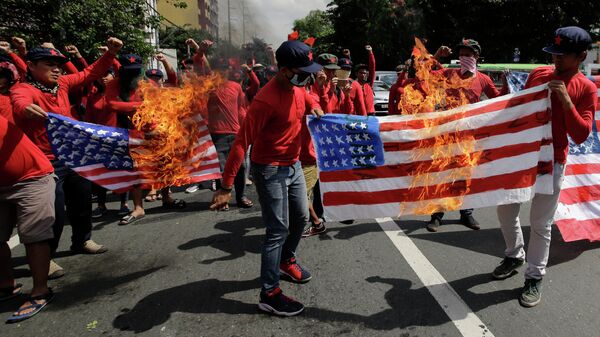 Протестующие жгут флаги США на улице в Маниле, Филиппины 