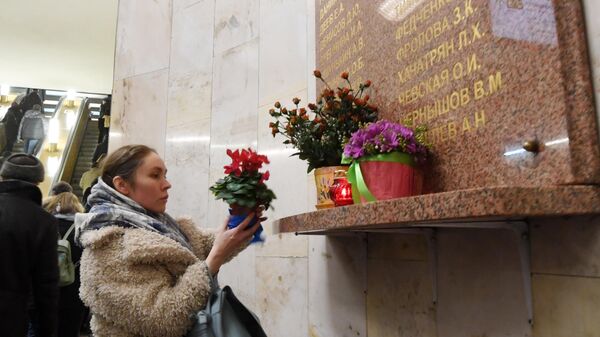 Женщина возлагает цветы на станции Автозаводская Замоскворецкой линии московского метрополитена в память о жертвах теракта 6 февраля 2004