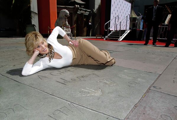 Американская актриса Джейн Фонда рядом с отпечатком рук и ног ее покойного отца Генри Фонда на голливудском бульваре