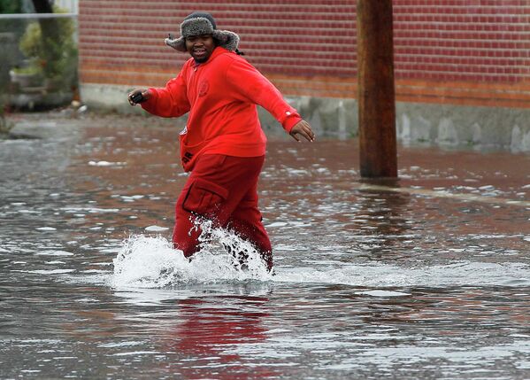 Человек идет по затопленному району Куинс в Нью-Йорке