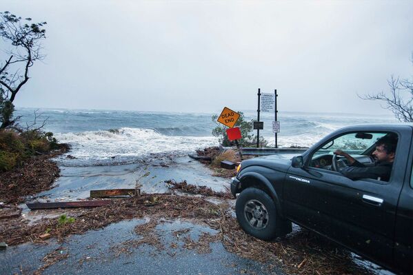 Водитель смотрит на волны, вызванные ураганом Сэнди в Саутгемптоне, Нью-Йорк