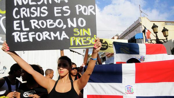 Участница демонстрации против налоговой реформы в Доминикане 