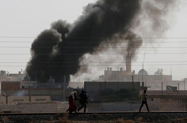 Дым от взрывов в сирийском город Рас-аль-Айн, расположенном недалеко от границы с Турцией