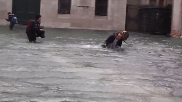 Туристы спотыкаются и падают в воду на затопленной площади Сан-Марко в Венеции