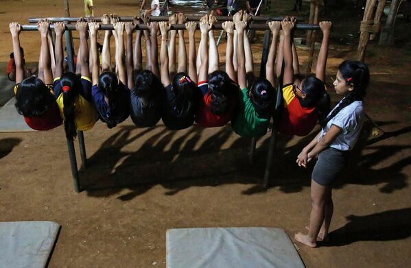 Девочки демонстрируют индийскую гимнастику Mallakhamb