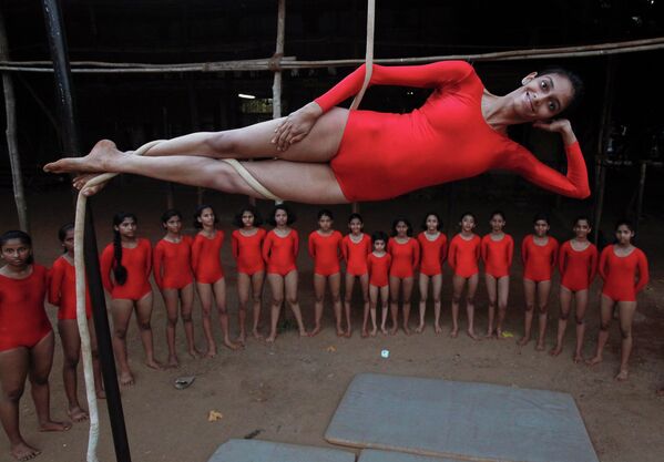 Девушка демонстрирует индийскую гимнастику Mallakhamb