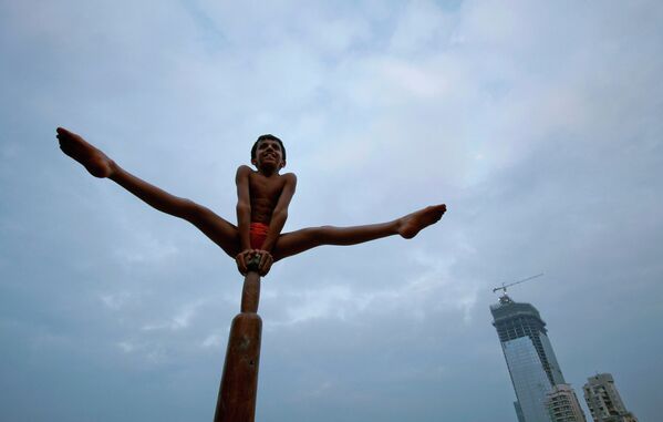 Мальчик демонстрирует индийскую гимнастику Mallakhamb