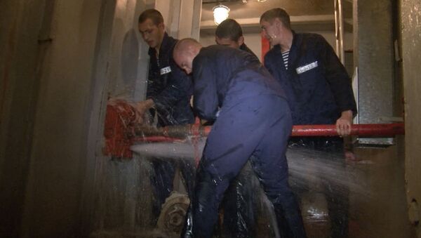 Военные моряки учатся заделывать пробоины под струями холодной воды