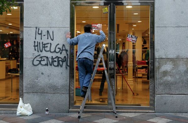 Мужчина очищает здание после всеобщей забастовки в Мадриде