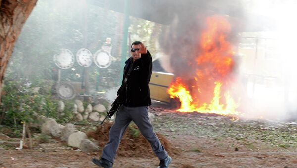 Израильский полицейский возле горящего автомобиля