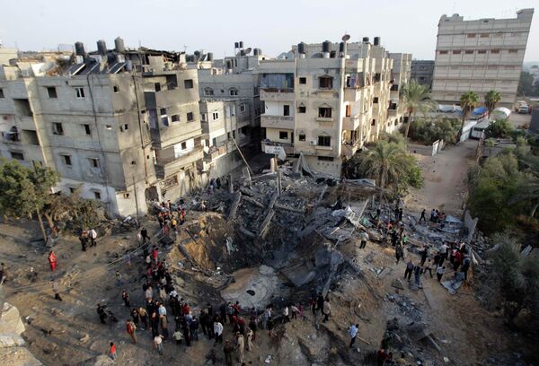 Палестинцы собираются вокруг разрушенного израильским авиаударом дома в южной части сектора Газа