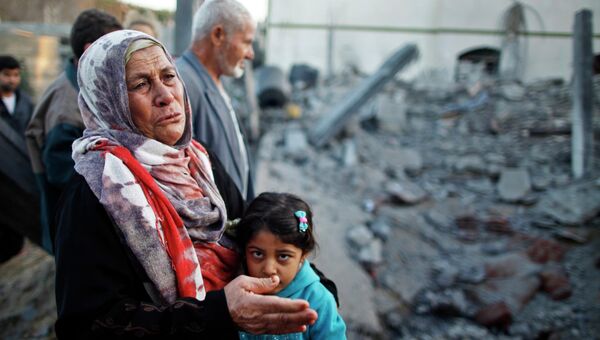 Палестинская женщина плачет рядом с домом, разрушенным после израильского авиаудара  в северной части сектора Газа