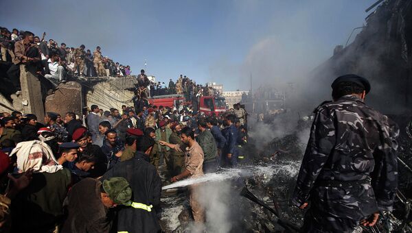 Пожарные работают на месте крушения военно-транспортного самолета в Сане, Йемен