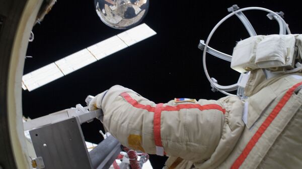 Космонавт Геннадий Падалка запускает микроспутник Сфера во время выхода в открытый космос