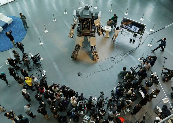 Представители СМИ у боевого робота Kuratas на выставке в Токио, Япония