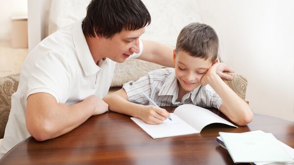 Папа помогает сыну делать домашнее задание
