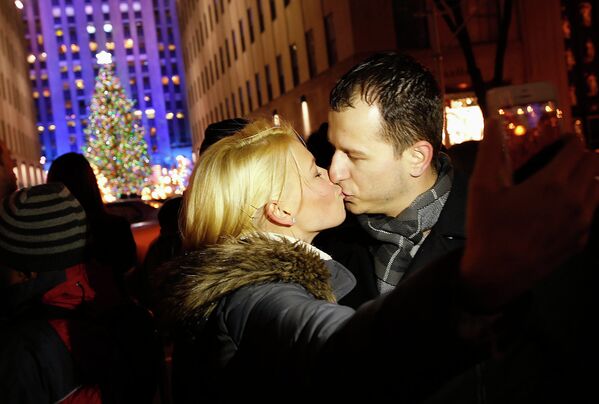 Молодая пара целуется на церемонии зажжения рождественской елки на Рокфеллер-плаза в Нью-Йорке 