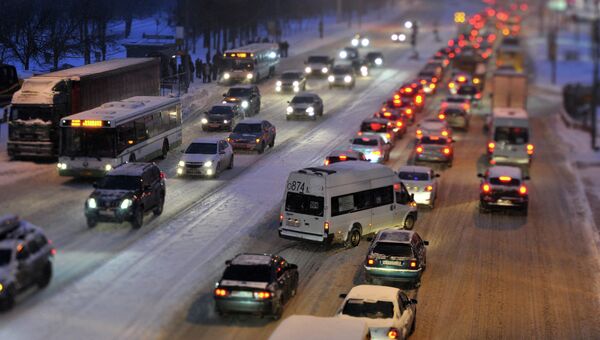 Автомобильное движение во время снегопада на улице Профсоюзная в Москве