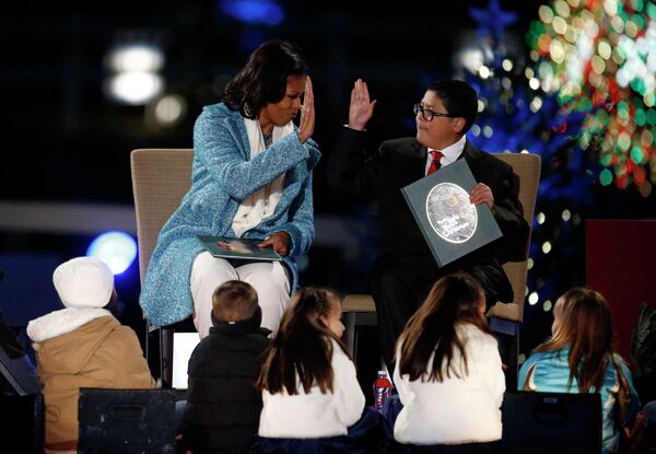 Мишель Обама и актер  Рико Родригез на церемонии зажжения Национальной рождественской ели в Вашингтоне, США 