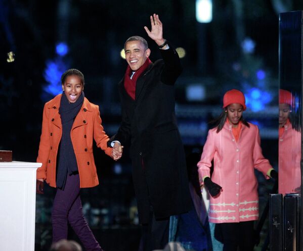 Барак Обама с дочерьми на церемонии зажжения Национальной рождественской ели в Вашингтоне, США
