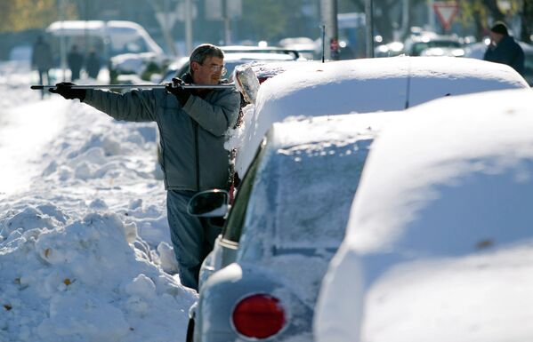 Мужчина чистит машину от снега в Загребе, Хорватия