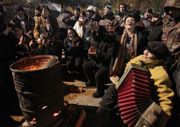 Сторонники Аллы Джиоевой поют песни возле очага на центральной площади Цхинвали, 5 декабря 2012.