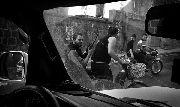 Повстанцы Свободной сирийской армии патрулируют улицу в сирийском городе Хомс, 22 апреля 2012.