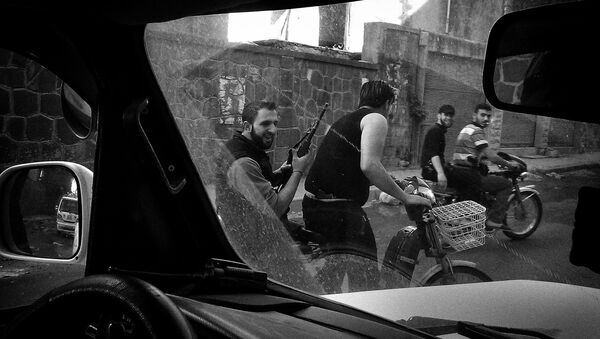 Повстанцы Свободной сирийской армии патрулируют улицу в сирийском городе Хомс, 22 апреля 2012.